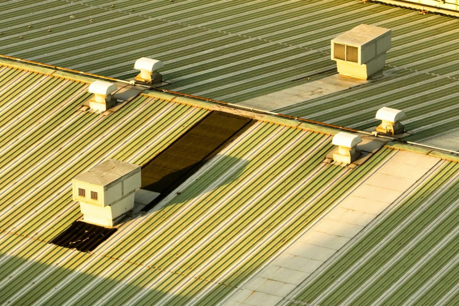 A commercial metal roof with rooftop ventilation units