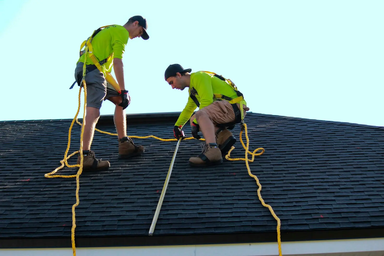 Two Hartline roofers working together on a shingle roof