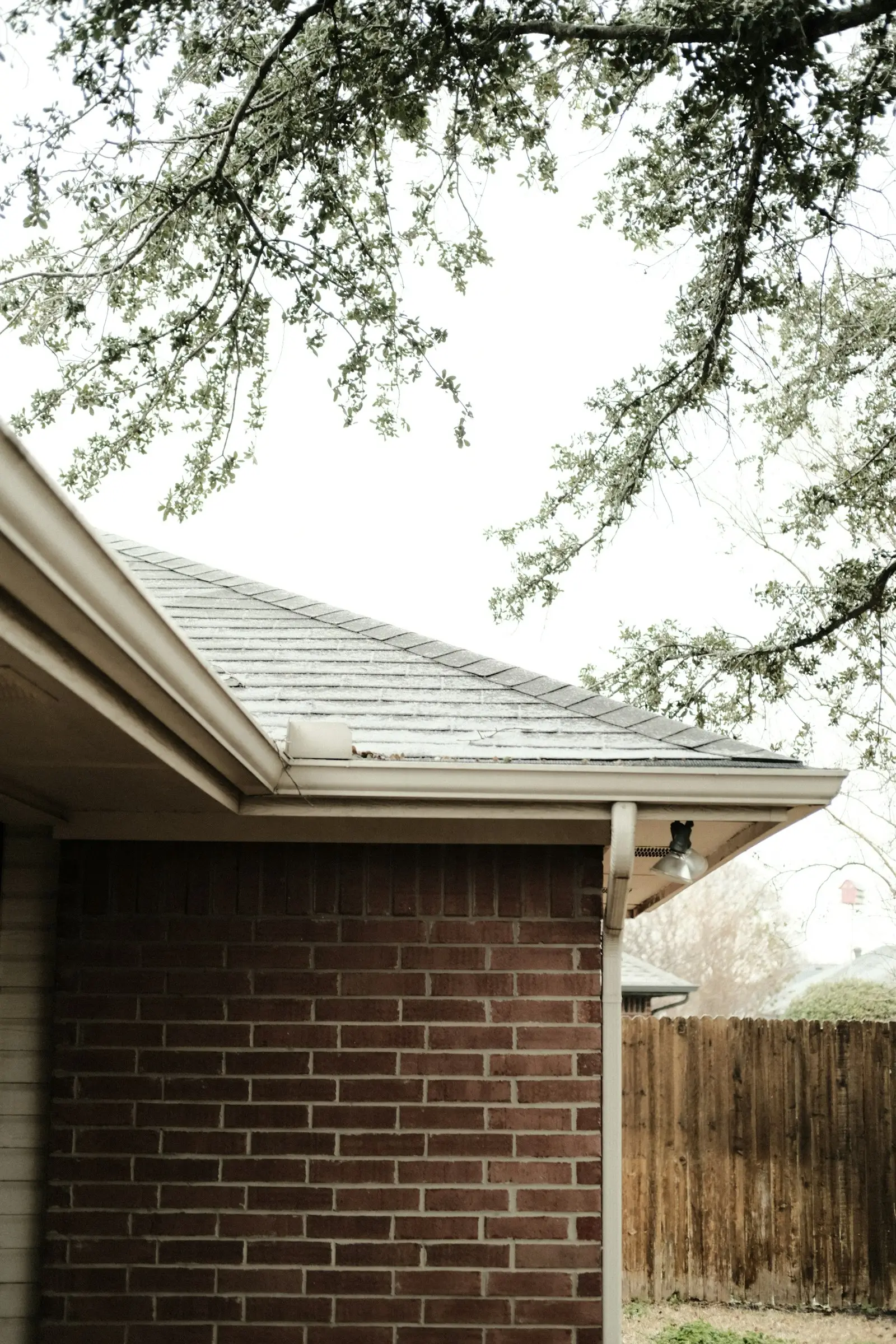 White seamless gutter and fascia at the corner of a roof