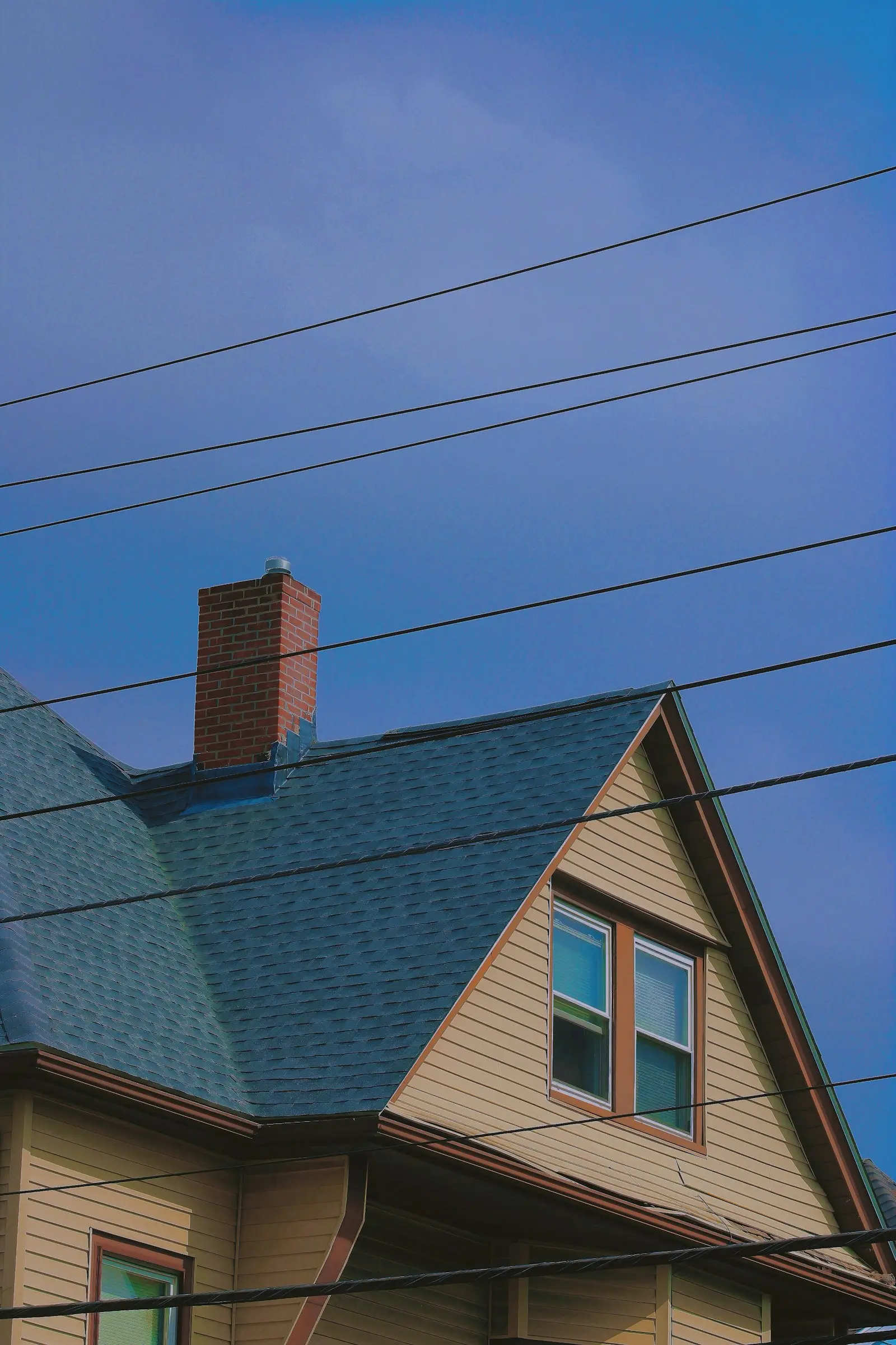 Shingle roof and chimney against a winter blue sky