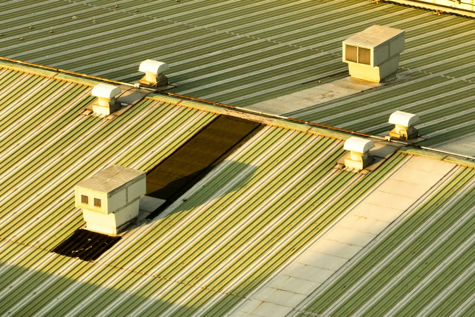 A commercial metal roof with rooftop ventilation units