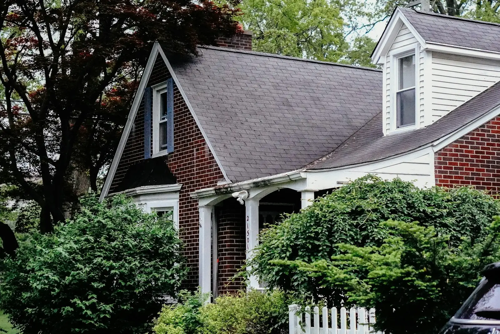 Brick Cape Cod home with dormers and a new shingle roof