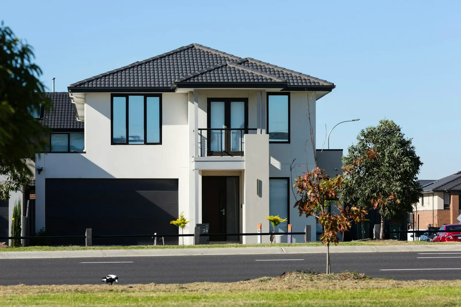 Modern white two story house with a dark tile roof